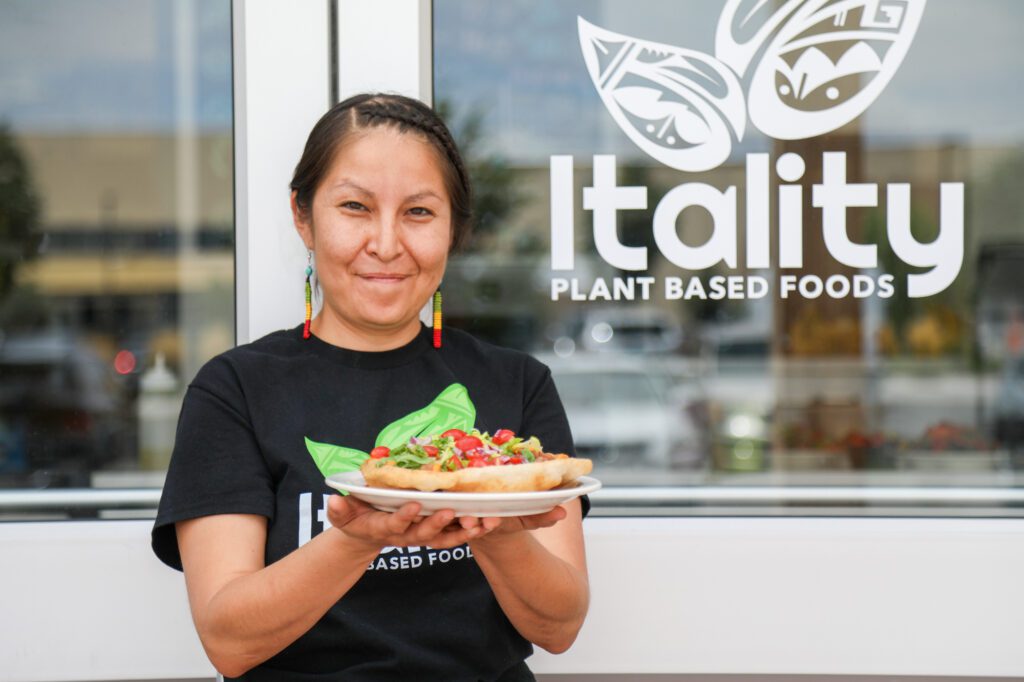 Tina Archuleta stands outside of Itality, holding a plate of food